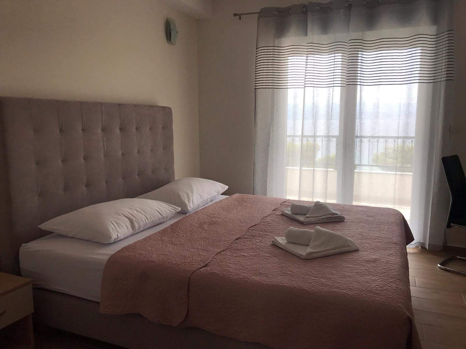 Bedroom with tufted headboard and fresh towels