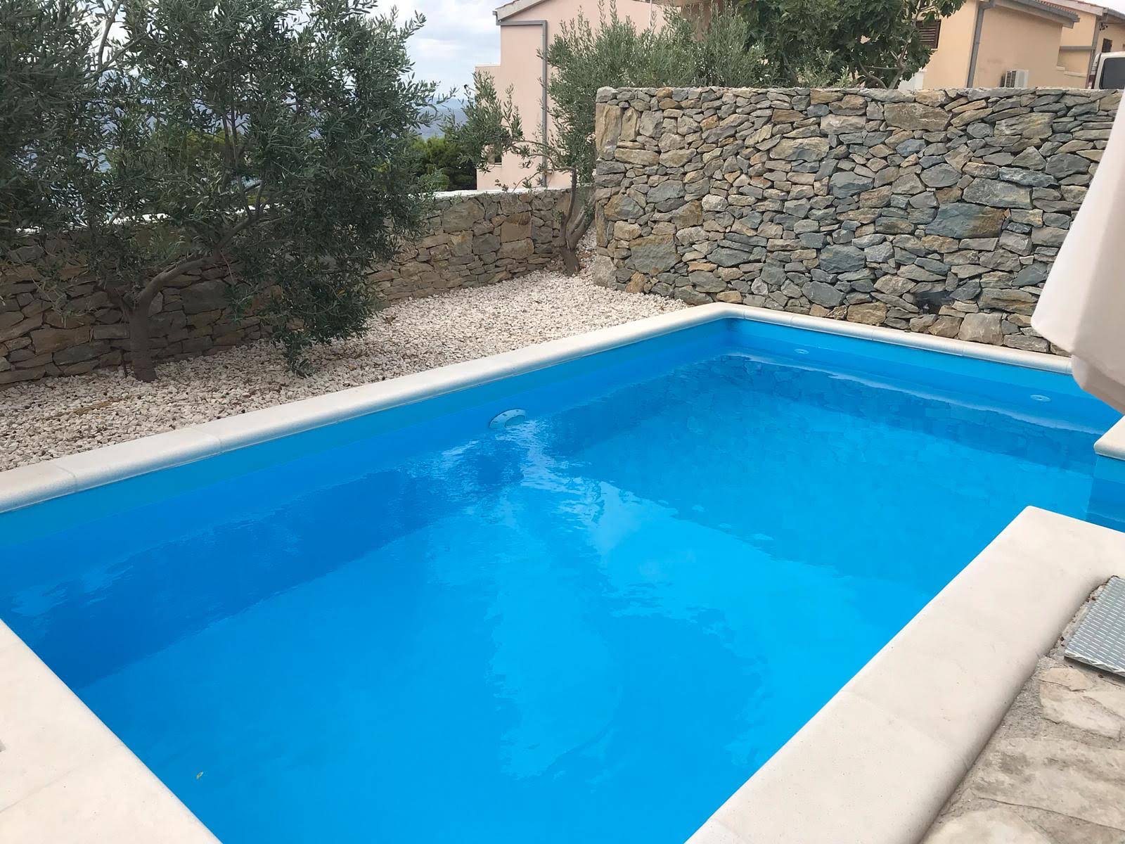 Pool terrace with sun loungers, umbrella, and sea view